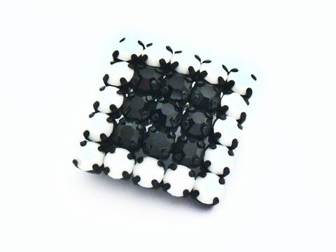 Schwarz-weiße Strass Brosche im sexy City Look, hergestellt von Juwelier Harnisch. Die Brosche besticht durch ihr elegantes Design und die auffällige Farbgebung in Schwarz.