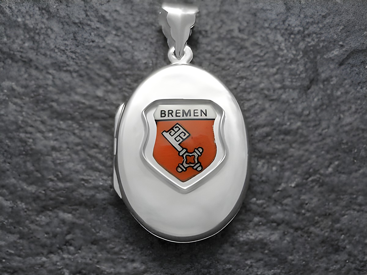 Ein silbernes Medaillon mit dem Wappen von Bremen, das ein orangefarbenes Schild zeigt. Das Wappen enthält die Inschrift Bremen und emblematische Symbole. Hersteller ist Juwelier Harnisch aus Bremen.