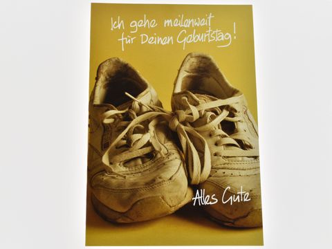 Eine Geburtstagskarte zeigt ein Paar alte Turnschuhe auf einem gelben Hintergrund, mit der Aufschrift Ich gehe mailenway für Deinen Geburtstag und Alles Gute. Hersteller Juwelier Harnisch.