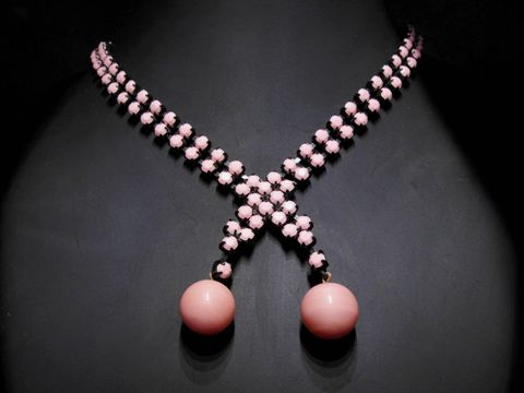 Im Bild ist eine beeindruckende Strasskette in pink zu sehen. Der Strassschmuck misst 41 cm und besitzt eine schwarze Fassung. Hersteller ist Juwelier Harnisch.