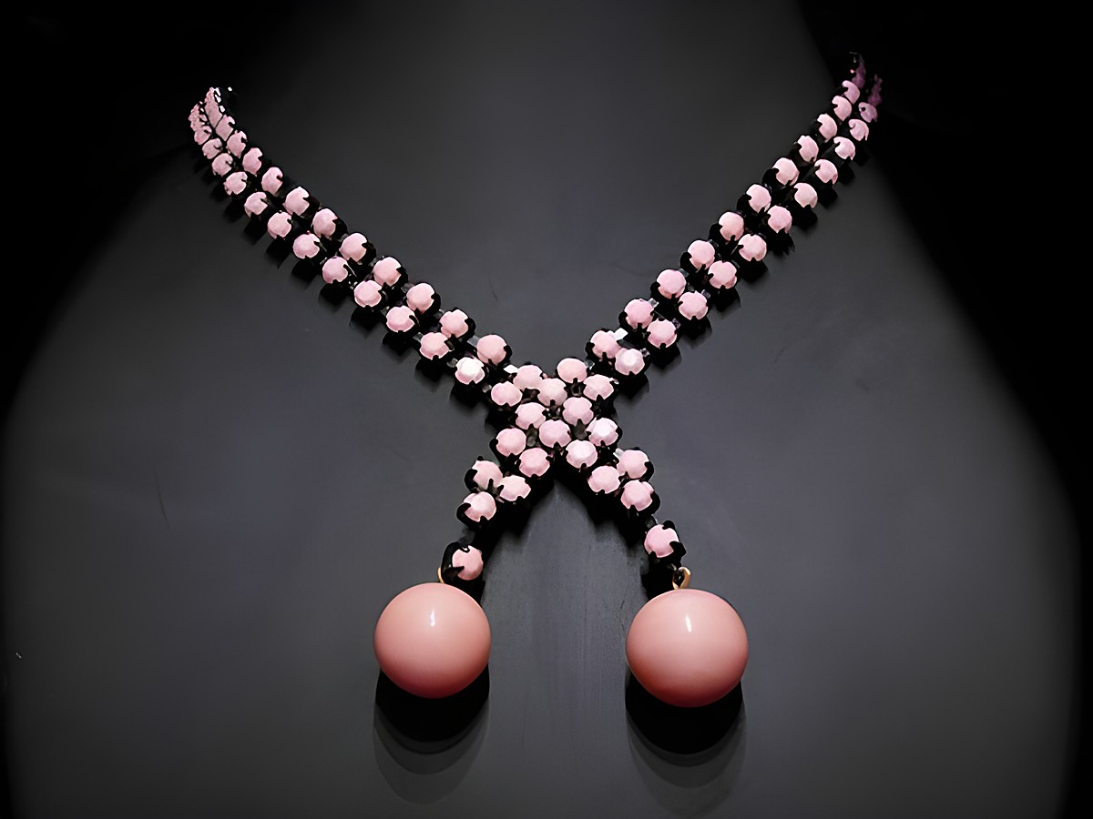 Im Bild ist eine beeindruckende Strasskette in pink zu sehen. Der Strassschmuck misst 41 cm und besitzt eine schwarze Fassung. Hersteller ist Juwelier Harnisch.