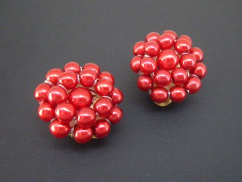 Ohrclip in Rot mit perlendem Traumdesign aus goldfarbenen Materialien und synthetischen Zuchtperlen, hergestellt vom Juwelier Harnisch.