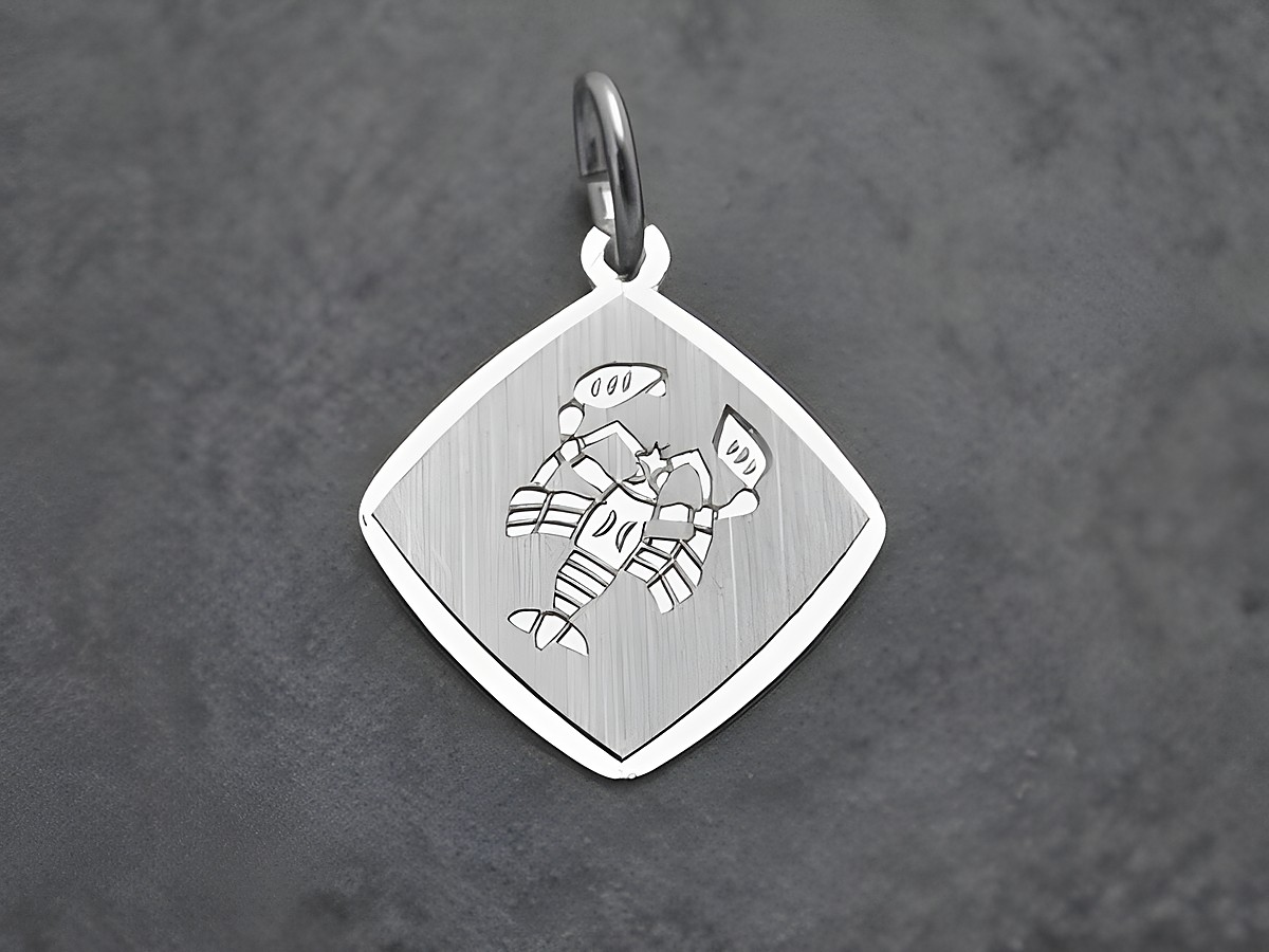 Ein Anhänger aus rhodiniertem Sterling Silber im Design des Sternzeichens Krebs, hergestellt von Juwelier Harnisch, in quadratischer Form mit eingraviertem Krebs-Motiv.