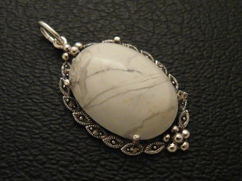 Cabochon aus Howlith in Weiß, eingefasst in Silber als Medaillon Anhänger, Hersteller Juwelier Harnisch, elegantes Design mit feinen Details.