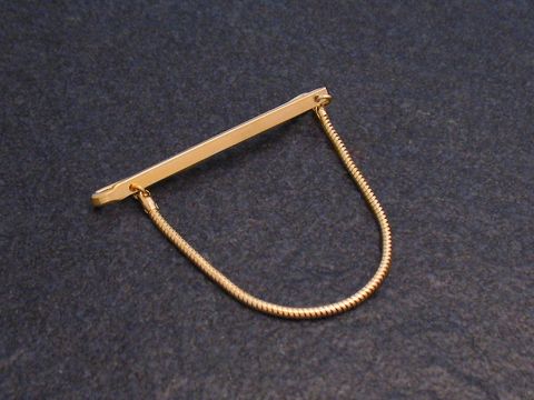 Krawattenklammer im Stil der 70er Jahre mit Vergoldung und Kette, Hersteller Juwelier Harnisch, ideal für elegante Anlässe und modische Akzente.