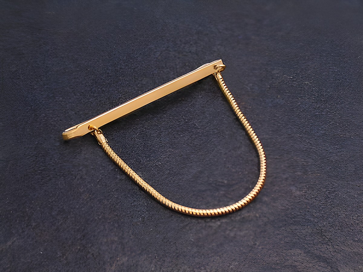 Krawattenklammer im Stil der 70er Jahre mit Vergoldung und Kette, Hersteller Juwelier Harnisch, ideal für elegante Anlässe und modische Akzente.