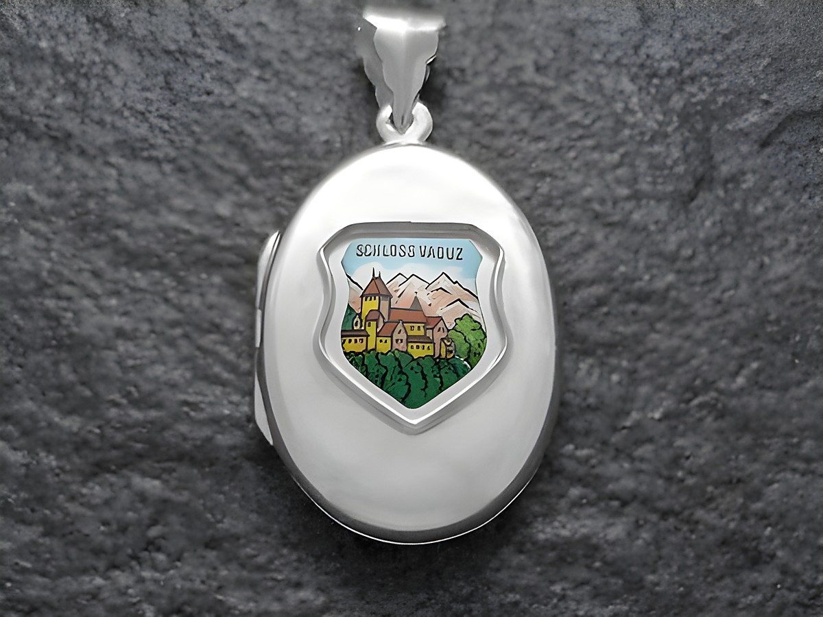Silber Medaillon mit dem Motiv von Schloss Vaduz, Liechtenstein, gefertigt vom Juwelier Harnisch, zeigt eine farbige Darstellung des Schlosses umgeben von grüner Natur und Bergen.