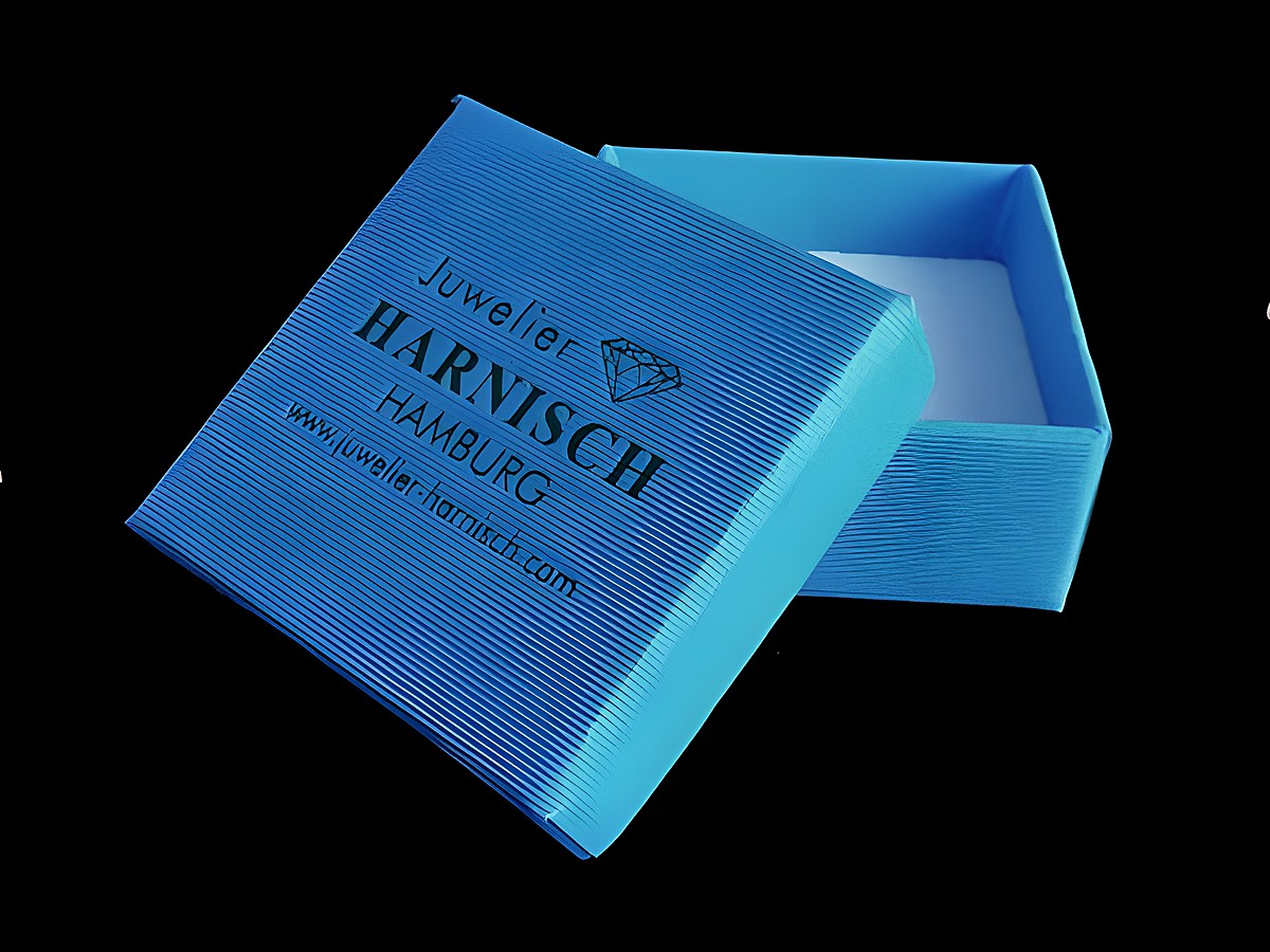 Geschenkschachtel in Blau, 4 x 4 cm, von Juwelier Harnisch. Die Box ist geöffnet und zeigt das Innere, ideal für Schmuckpräsentationen. Hersteller: Juwelier Harnisch aus Hamburg.