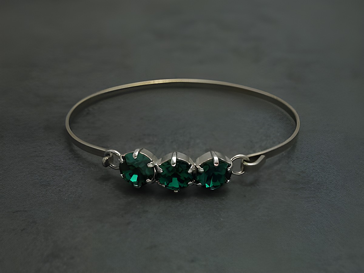 Dunkelgrüner Strass Armreifen mit drei funkelnden Steinen, 18 cm lang, silberfarbener Metallrahmen, feminin, Hersteller Juwelier Harnisch. Ideal für elegante Anlässe.
