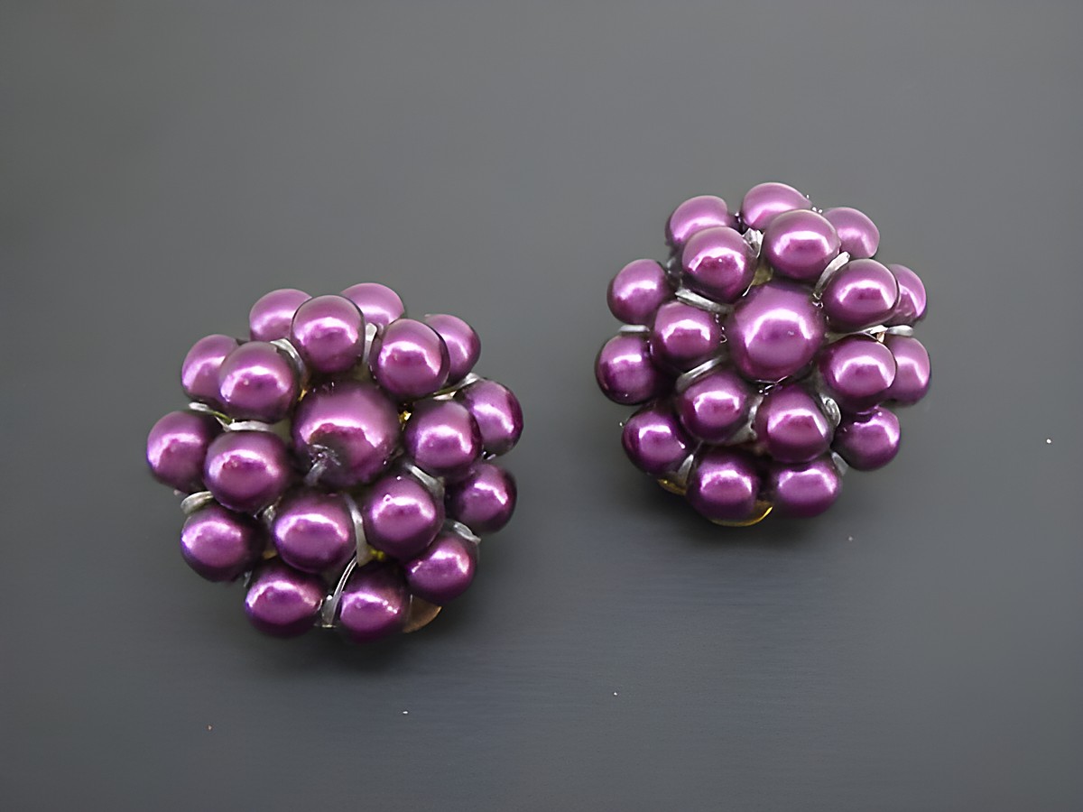 Dunkellila Perlentraum Ohrclips aus synthetischen Zuchtperlen in goldfarbener Fassung, hergestellt von Juwelier Harnisch, elegant und geschmackvoll gestaltet.