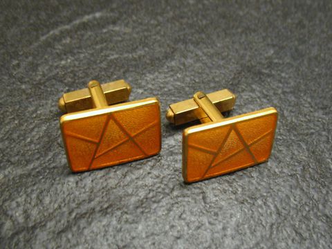 Manschettenknöpfe in light gelb-gold mit vergoldeter Emaille, rechteckige Form mit geometrischem Muster, hergestellt von Juwelier Harnisch, elegantes Accessoire für besondere Anlässe.