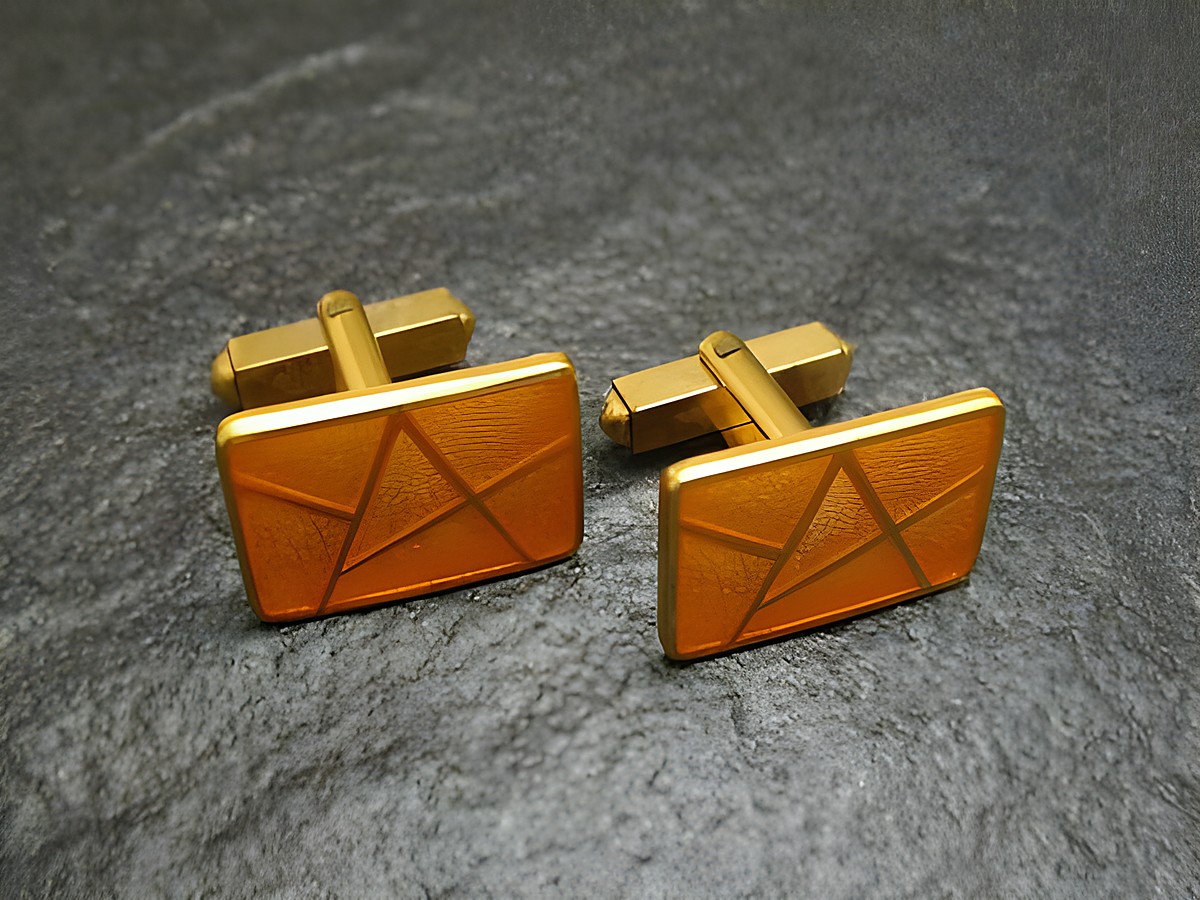 Manschettenknöpfe in light gelb-gold mit vergoldeter Emaille, rechteckige Form mit geometrischem Muster, hergestellt von Juwelier Harnisch, elegantes Accessoire für besondere Anlässe.