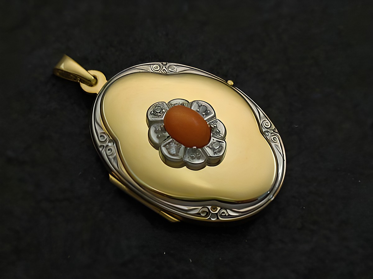 Medalion aus Gelbgold 333 mit bicolor Design, mit einem Koralle natur Cabochon und Brillanten verziert, gefertigt vom Juwelier Harnisch. Elegantes Schmuckstück mit einem klassischen Look.