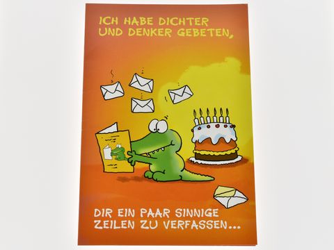 Eine Geburtstagkarte mit einem kleinen Krokodil, das an einem Tisch sitzt, umgeben von Briefumschlägen und einer Torte mit Kerzen, und den Text „Ich habe Dichter und Denker gebeten, dir ein paar sinnige Zeilen zu verfassen“.