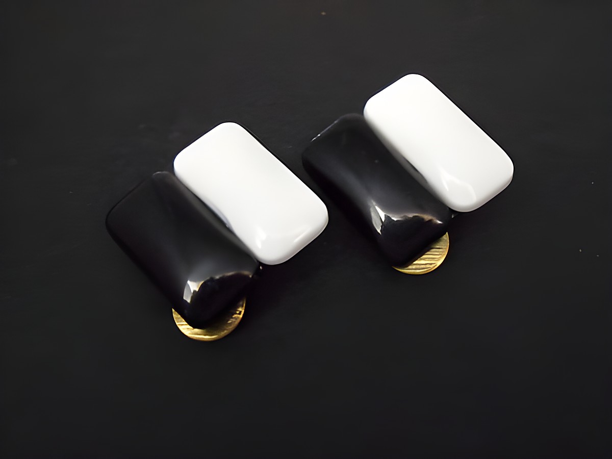 Ohrclip in zeitlosem Schwarz-Weiß Design mit goldfarbenen Akzenten aus Kunstharz, hergestellt von Juwelier Harnisch, elegant und modisch.