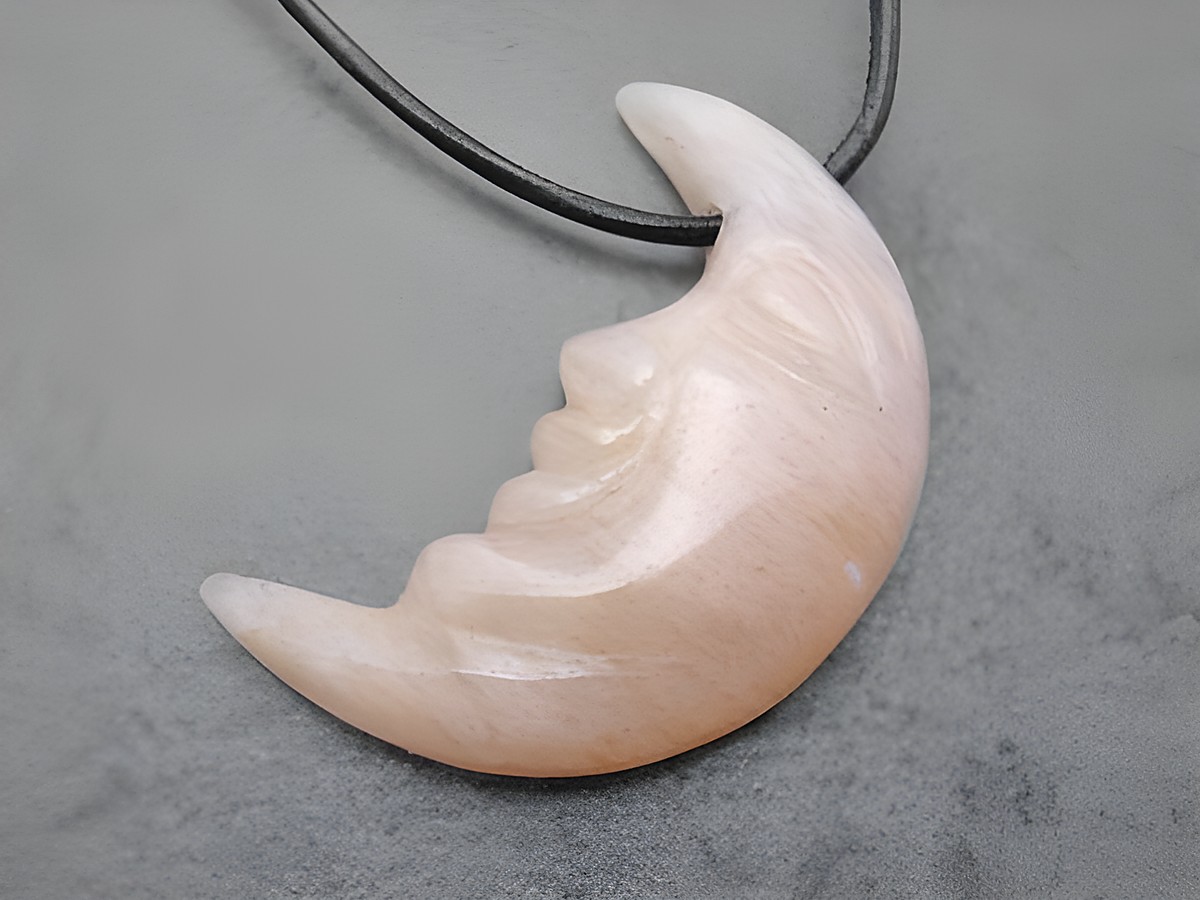 Mondgesicht Anhänger aus milchigem braunem Aragonit mit ausdrucksstarker Gestaltung, inklusive 1 Meter Lederband, hergestellt von Juwelier Harnisch, idealer Edelstein Schmuck.