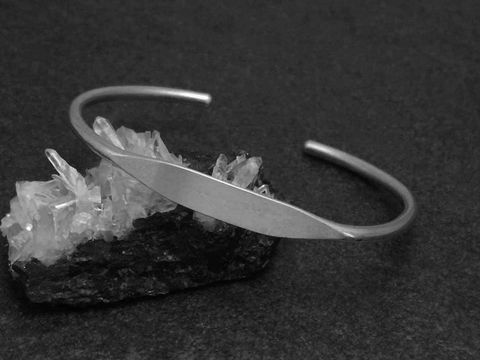 Silber Armreifen - blank - 6,6 mm - 17 cm, Hersteller: Juwelier Harnisch, eleganter Armreifen auf schwarzem Untergrund mit Kristallstruktur im Hintergrund. Perfekte Ergänzung für jedes Outfit.