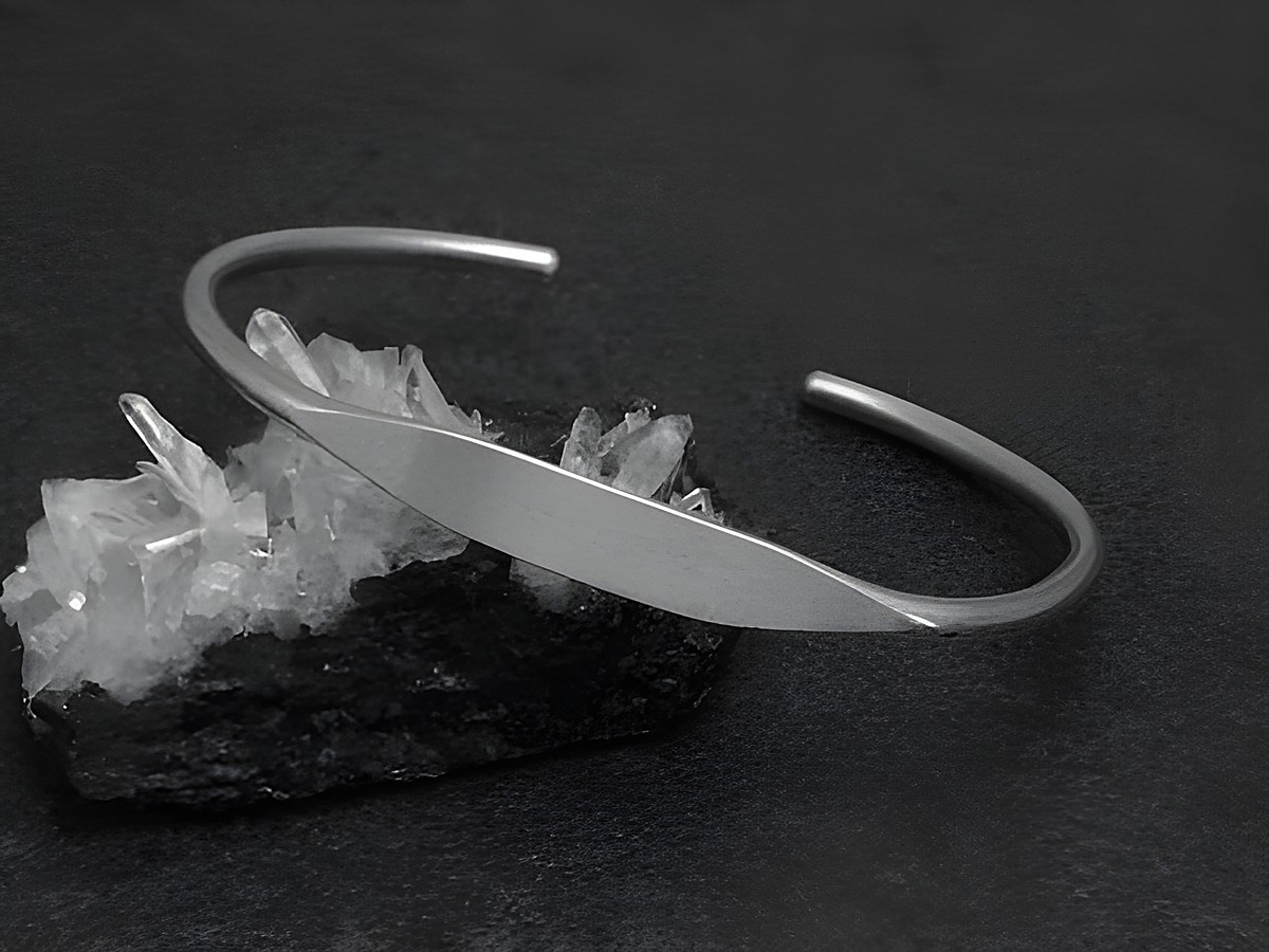 Silber Armreifen - blank - 6,6 mm - 17 cm, Hersteller: Juwelier Harnisch, eleganter Armreifen auf schwarzem Untergrund mit Kristallstruktur im Hintergrund. Perfekte Ergänzung für jedes Outfit.