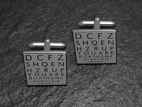 Silberfarbene Manschettenknöpfe des Herstellers Juwelier Harnisch mit einem modernen, grafischen Design und schwarzer Schrift auf hellgrauem Hintergrund. Ideal für einen besonderen Anlass.