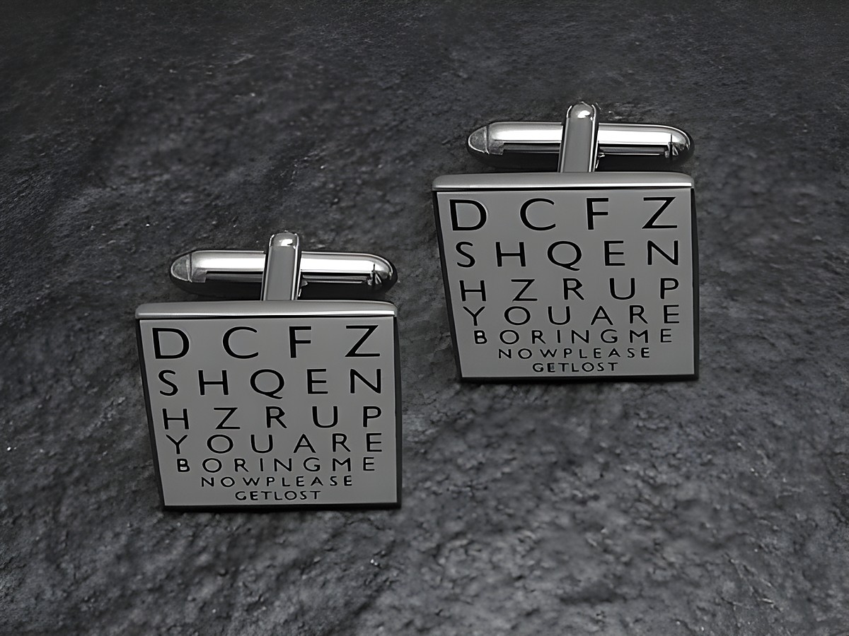 Silberfarbene Manschettenknöpfe des Herstellers Juwelier Harnisch mit einem modernen, grafischen Design und schwarzer Schrift auf hellgrauem Hintergrund. Ideal für einen besonderen Anlass.