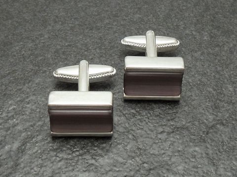 Designer Manschettenknöpfe in silberfarben mit lila und grauen Akzenten, hergestellt von Juwelier Harnisch, elegantes und modernes Design für stilvolle Anlässe.