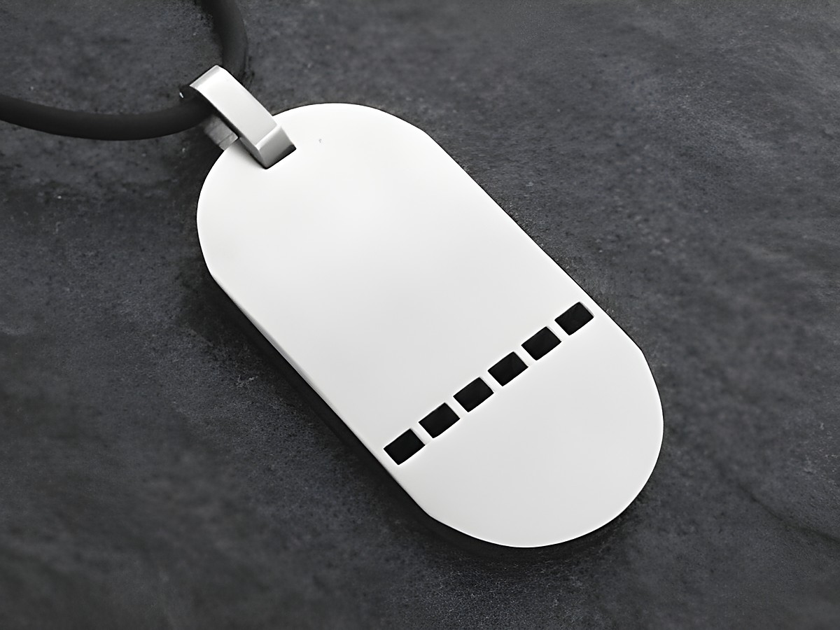 Edelstahl Anhänger mit einer Größe von 42 mm, schlichtes Design mit einer Gravurplatte und fünf vertikalen Einkerbungen, angebracht an einem schwarzen Halsband, Hersteller Juwelier Harnisch.