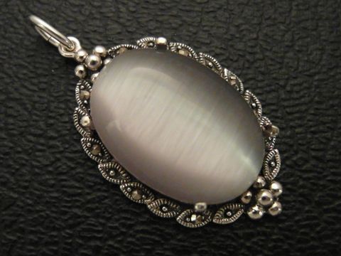 Cabochon Katzenauge grau in einem silbernen Medaillon Anhänger, Hersteller Juwelier Harnisch, mit dekorativem Design und glänzender Oberfläche. Perfekt für elegante Schmuckstücke.