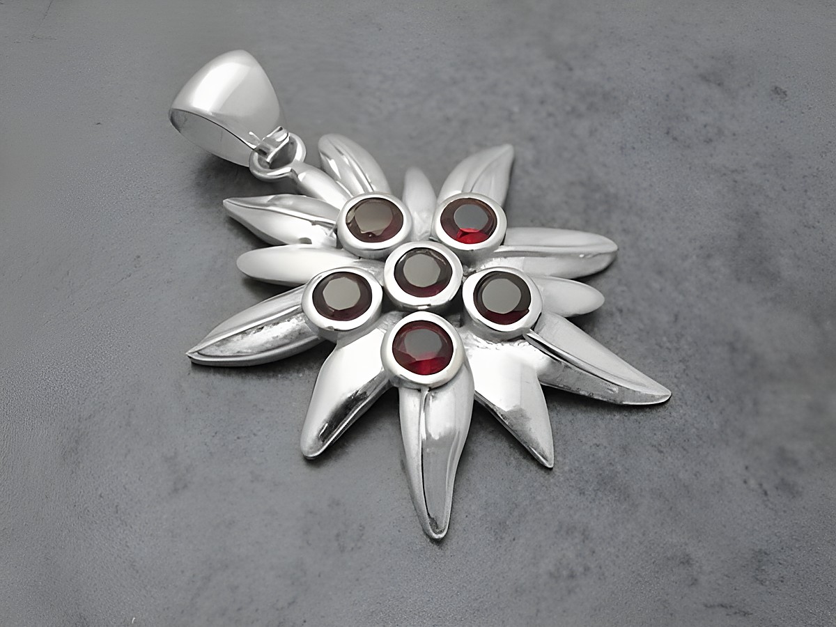 Edelweiß Silber Anhänger 43,4 mm mit feinen Granatsteinen in der Mitte, inspiriert von der Alpenblume, von Juwelier Harnisch, elegantes Schmuckstück für stilvolle Akzente.