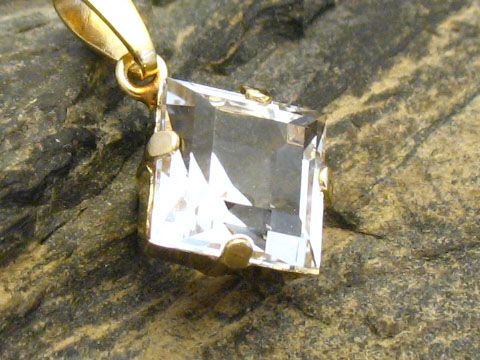 Gold Anhänger mit einem quadratischen Bergkristall, Gold 333, hergestellt von Juwelier Harnisch, der klare Stein ist in einer filigranen Fassung befestigt.