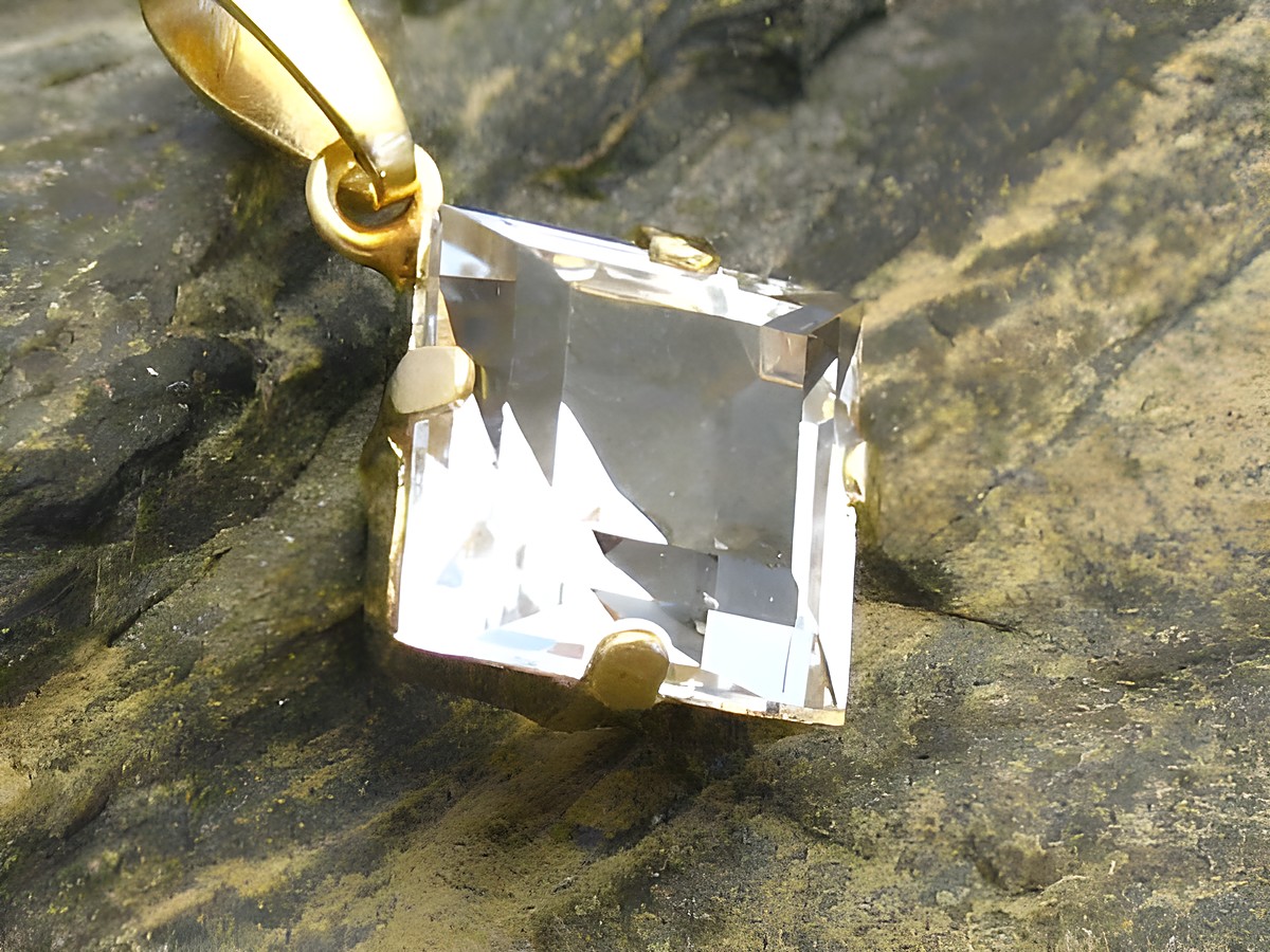Gold Anhänger mit einem quadratischen Bergkristall, Gold 333, hergestellt von Juwelier Harnisch, der klare Stein ist in einer filigranen Fassung befestigt.