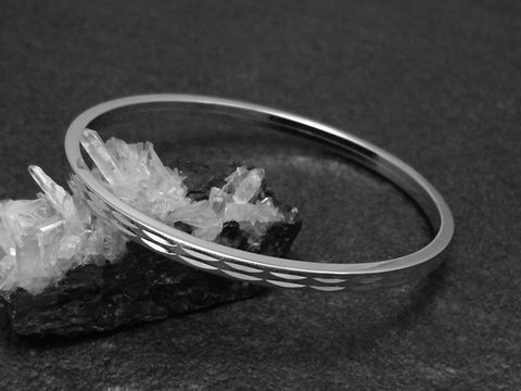 Silber Armreifen weiblich 4 mm rhodiniert 18 cm Hersteller Juwelier Harnisch Armreifen auf glitzerndem Hintergrund aus Kristall.