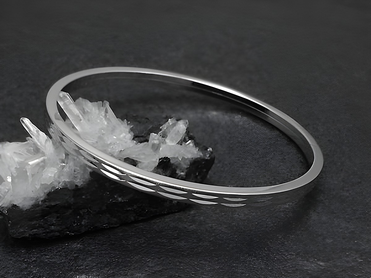 Silber Armreifen weiblich 4 mm rhodiniert 18 cm Hersteller Juwelier Harnisch Armreifen auf glitzerndem Hintergrund aus Kristall.