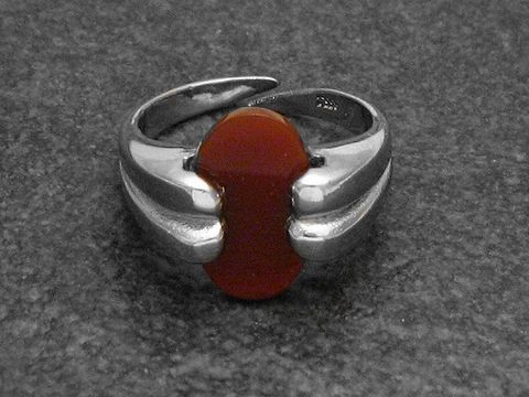 Silberring mit verstellbarem Design, verarbeitet mit einem roten Karneolstein und rhodiniertem Finish. Hersteller ist Juwelier Harnisch.