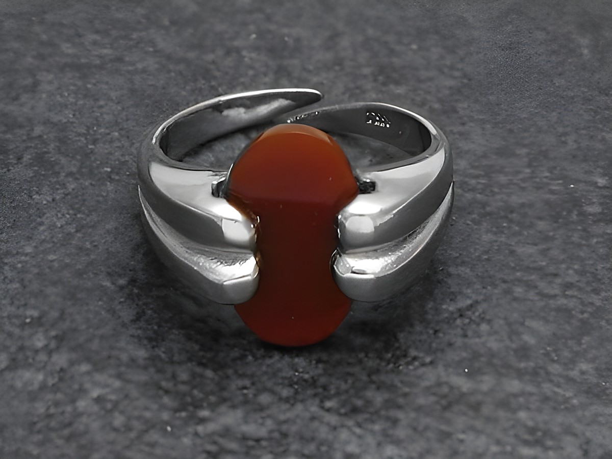 Silberring mit verstellbarem Design, verarbeitet mit einem roten Karneolstein und rhodiniertem Finish. Hersteller ist Juwelier Harnisch.