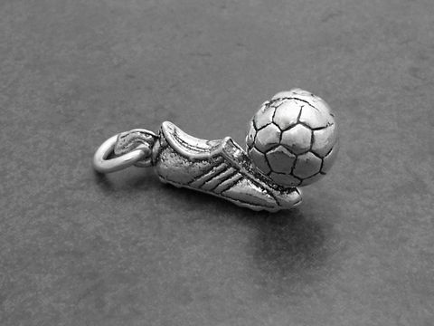 Fußballschuh mit einem kleinen silbernen Fußball Anhänger, hergestellt von Juwelier Harnisch, idealer Deutschland Fanartikel für Fußballliebhaber.