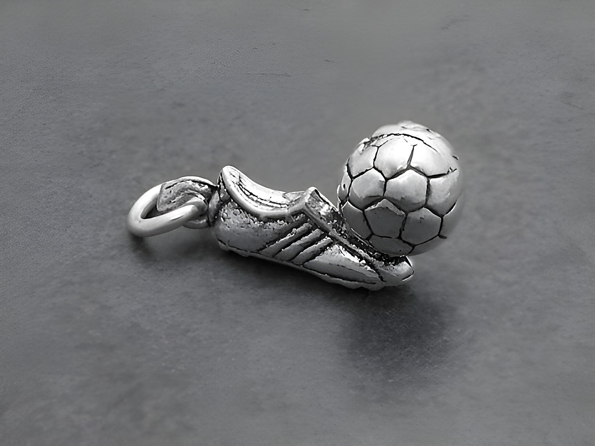 Fußballschuh mit einem kleinen silbernen Fußball Anhänger, hergestellt von Juwelier Harnisch, idealer Deutschland Fanartikel für Fußballliebhaber.