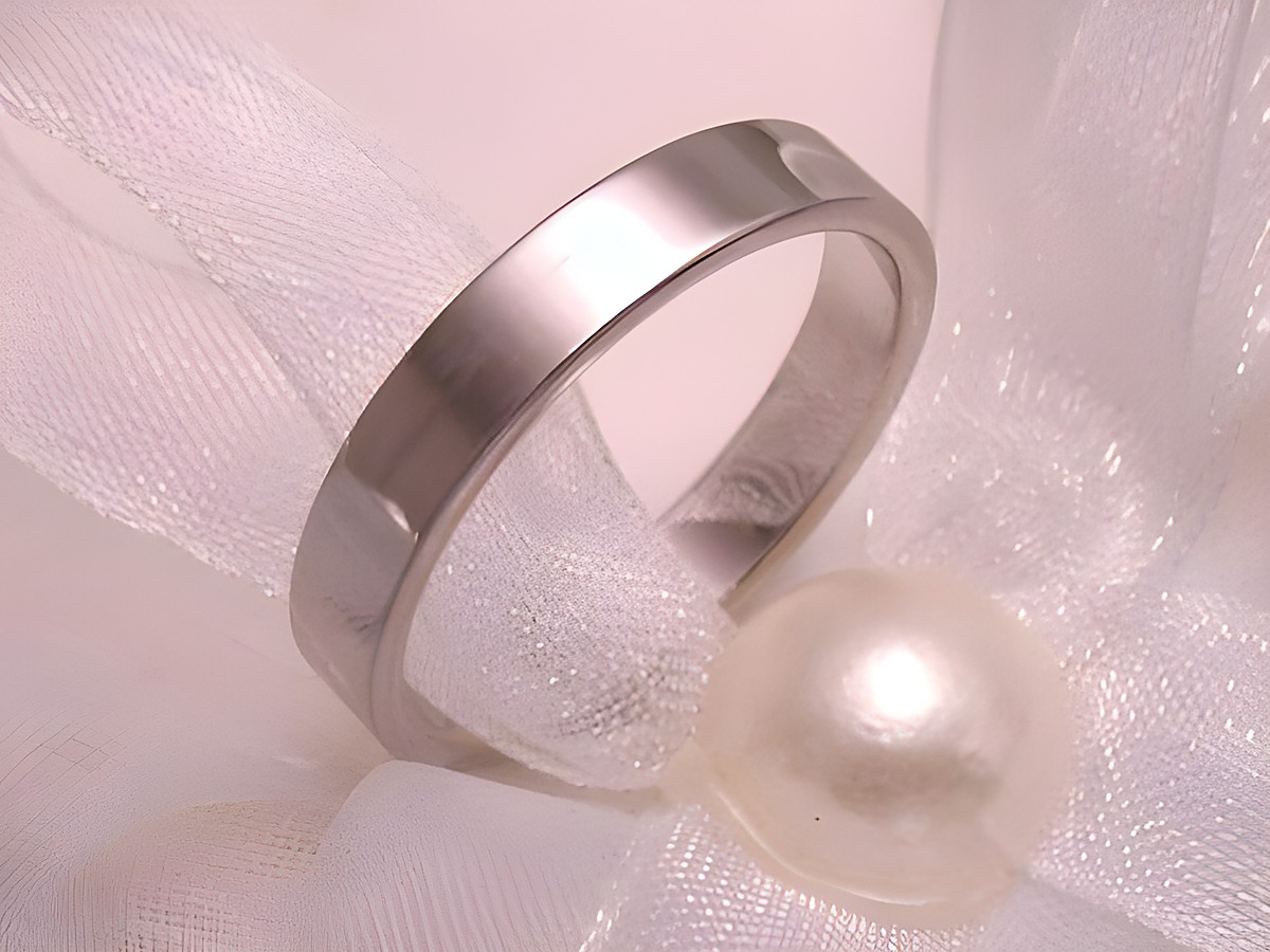 Trauring Ehering aus Weißgold 585, schlichtes Design, mit einer Breite von 6 mm, Hersteller Juwelier Harnisch, bis Größe 66/21,0, präsentiert auf einer zarten Stoffunterlage mit Perle.