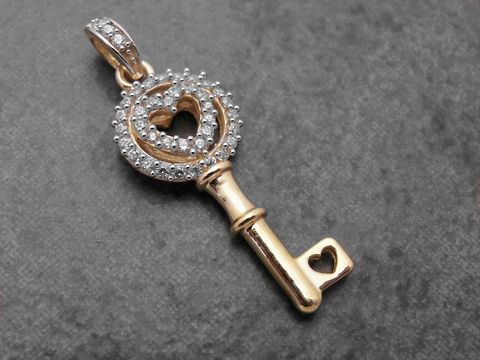 Schlüsselanhänger in Gelbgold mit Herz, verziert mit weißen Zirkonia, symbolisch für Liebe, Hersteller Juwelier Harnisch.