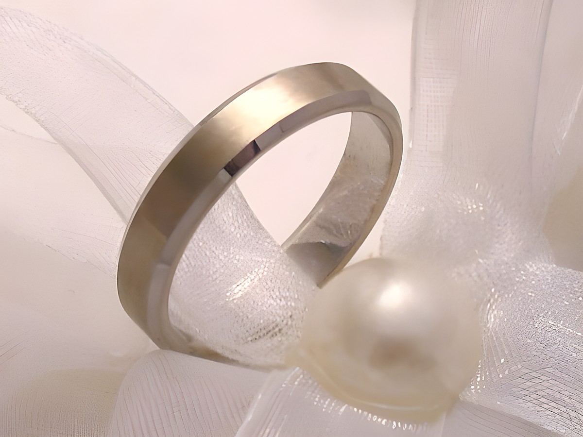 Trauring Ehering in schlichte Eleganz aus Weißgold 333, Größe 65/20,7, Hersteller Juwelier Harnisch, bis Größe 66/21,0, auf einem dekorativen Hintergrund mit einer Perle.