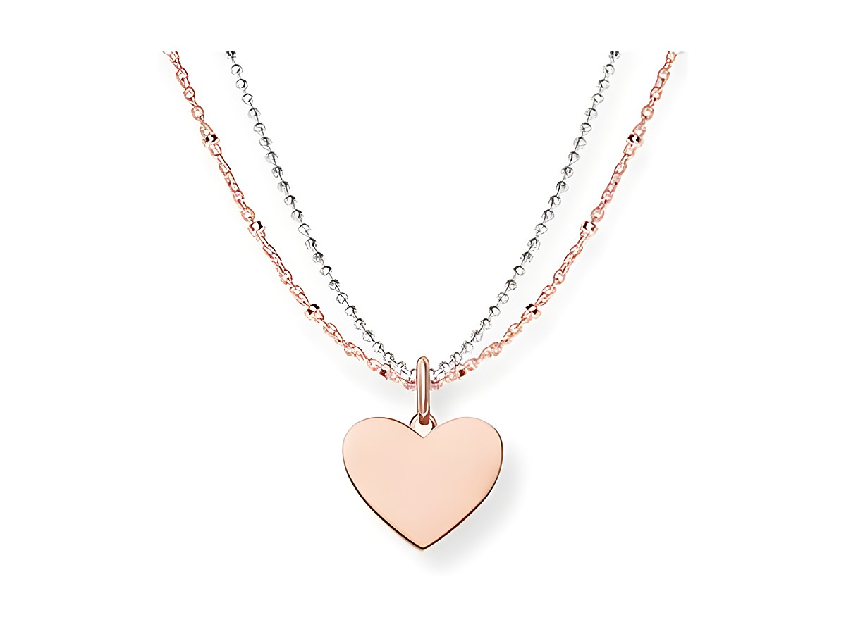 Zwei Ketten in Silber und vergoldetem Roségold mit einem herzförmigen Anhänger. Die Ketten haben eine Länge von 45 cm und stammen vom Hersteller Thomas Sabo.