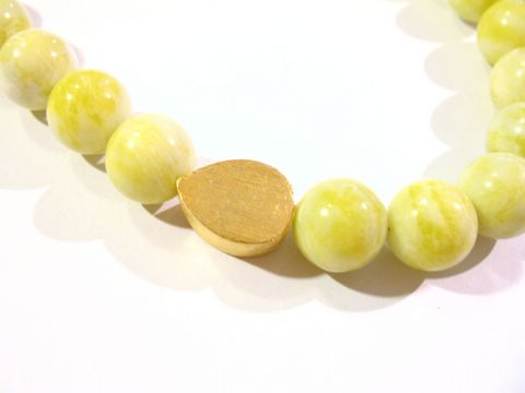 Conemara Serpentin Steinkette mit einer Länge von 51 cm, gefertigt von Juwelier Harnisch, zeigt grüne, runde Steine und eine goldene, tropfenförmige Zwischenperle.