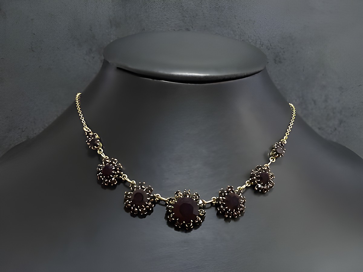 Strass Kette stilvoll in granatrotem Farbton, 44 cm lang, goldfarbene Fassung, gefertigt von Juwelier Harnisch. Elegante Akzente durch funkelnde Steine und edles Design.