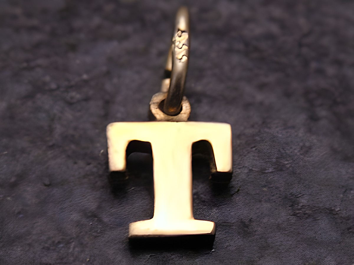 T Gold 333 Druck Buchstaben Anhänger in der Form des Buchstabens T, hergestellt von Juwelier Harnisch, glänzende Oberfläche, ideal als persönliches Schmuckstück oder Geschenk.