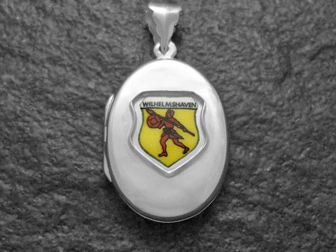 600004301-0 Das Bild zeigt ein silbernes Medaillon mit dem Stadtwappen von Wilhelmshaven, das einen Ritter darstellt. Der Hersteller ist Juwelier Harnisch aus Niedersachsen.