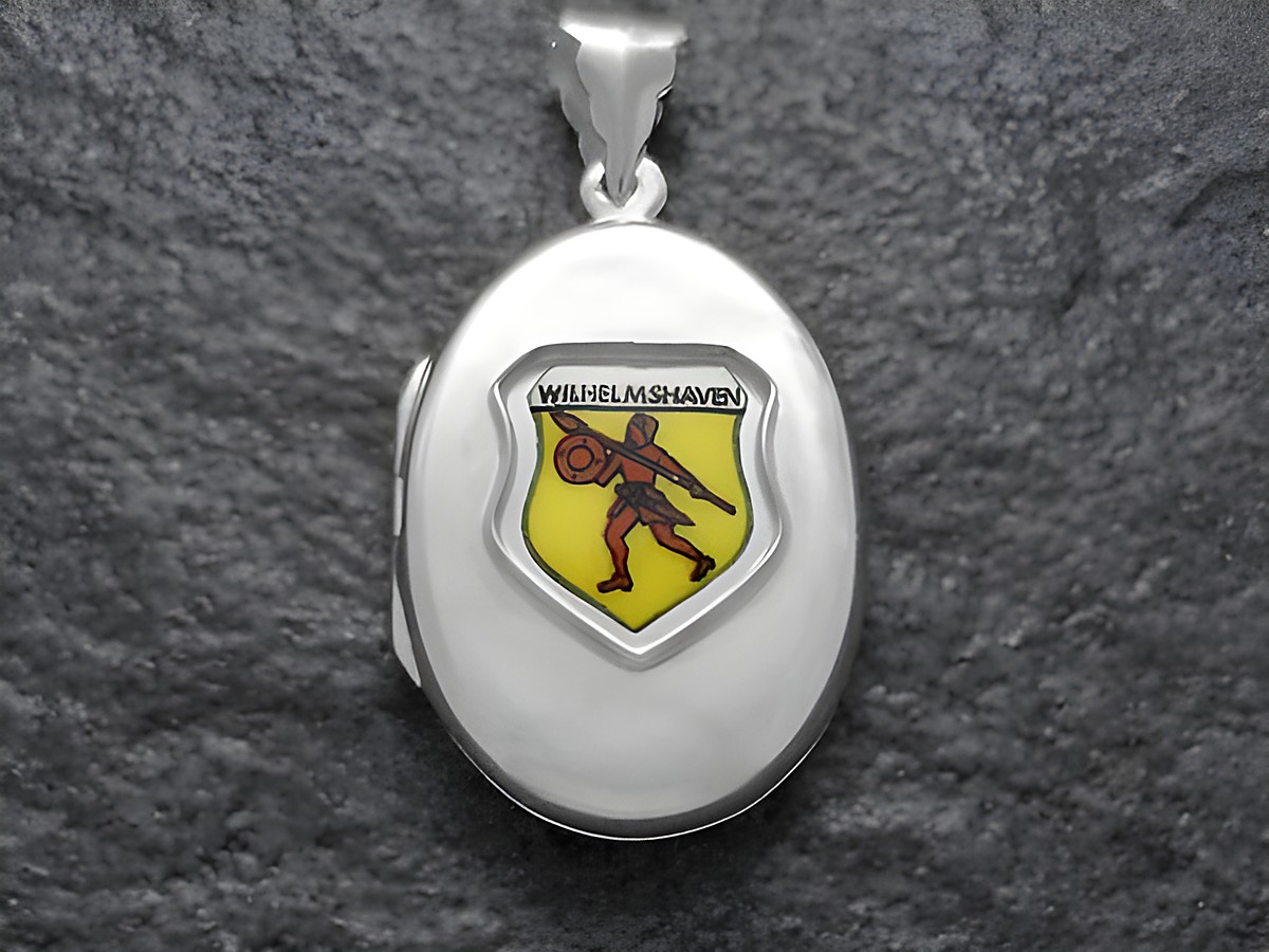 Das Bild zeigt ein silbernes Medaillon mit dem Stadtwappen von Wilhelmshaven, das einen Ritter darstellt. Der Hersteller ist Juwelier Harnisch aus Niedersachsen.