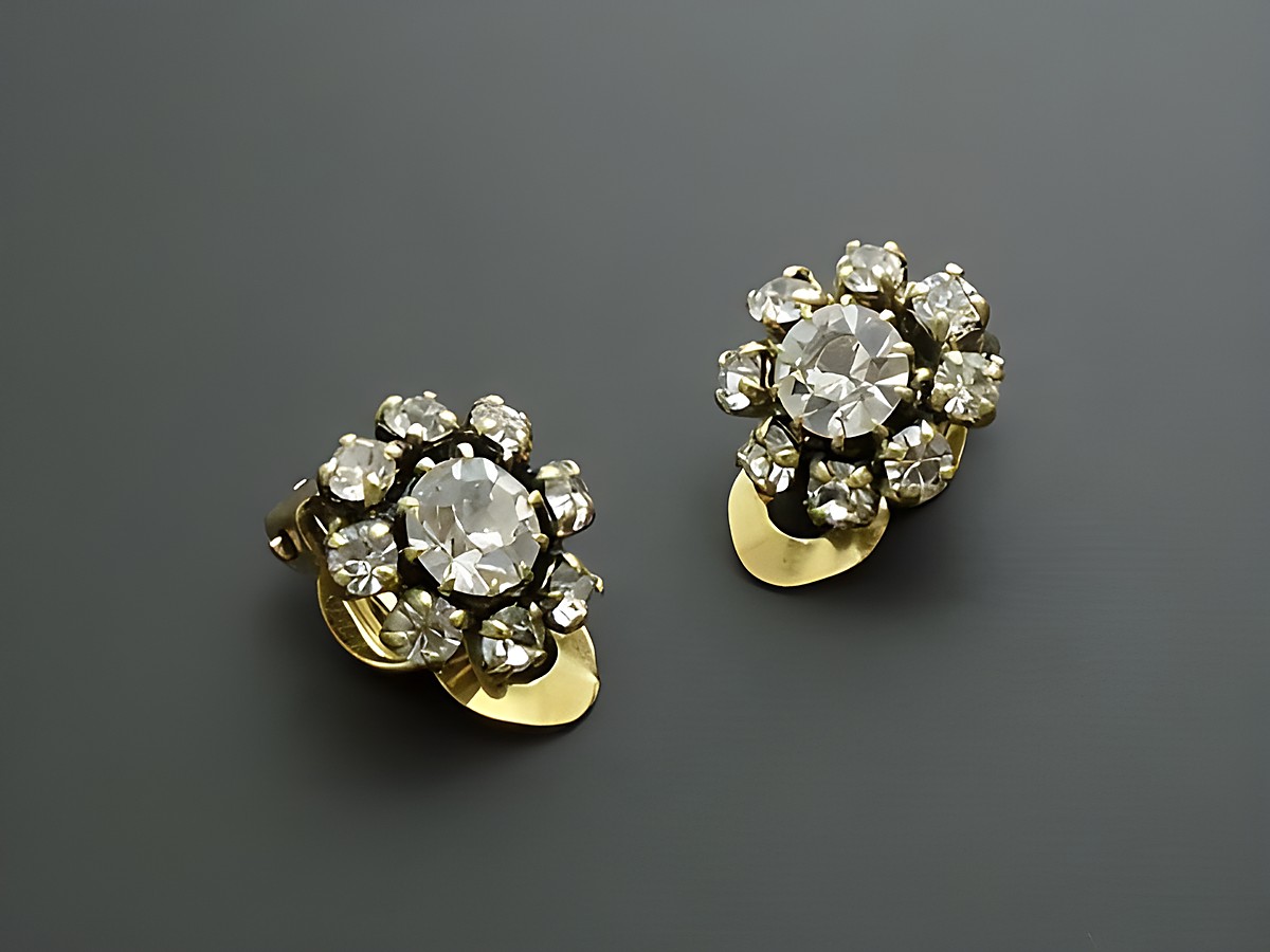 Strass Ohrclip feminin weiß Strass Schmuck von Juwelier Harnisch, glänzende Ohrclips mit funkelnden Kristallen in floraler Anordnung und goldfarbener Basis. Ideal für festliche Anlässe.