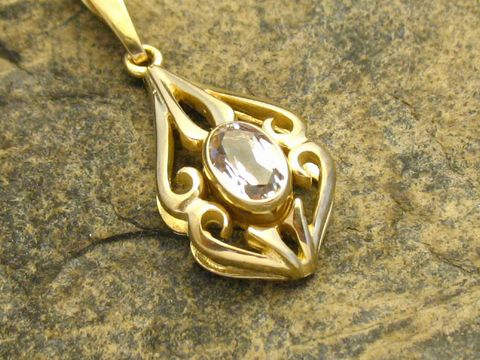 Gold Anhänger mit Schnörkel design, versehen mit einem ovalen Bergkristall, aus Gold 333, hergestellt von Juwelier Harnisch. Ideal für eleganten Schmuckliebhaber.