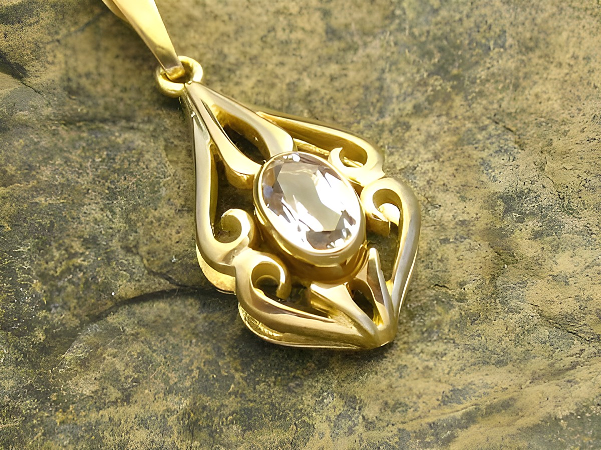Gold Anhänger mit Schnörkel design, versehen mit einem ovalen Bergkristall, aus Gold 333, hergestellt von Juwelier Harnisch. Ideal für eleganten Schmuckliebhaber.