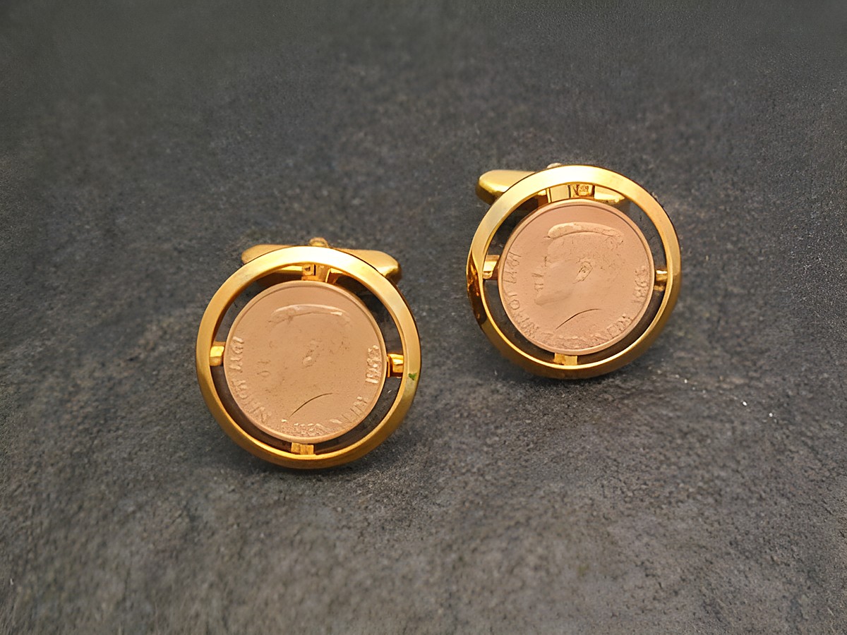 Vergoldete Manschettenknöpfe in Münz-Optik mit dem Abbild von J.F. Kennedy, hergestellt von Juwelier Harnisch, in goldfarbener Ausführung und stilvollem Design.