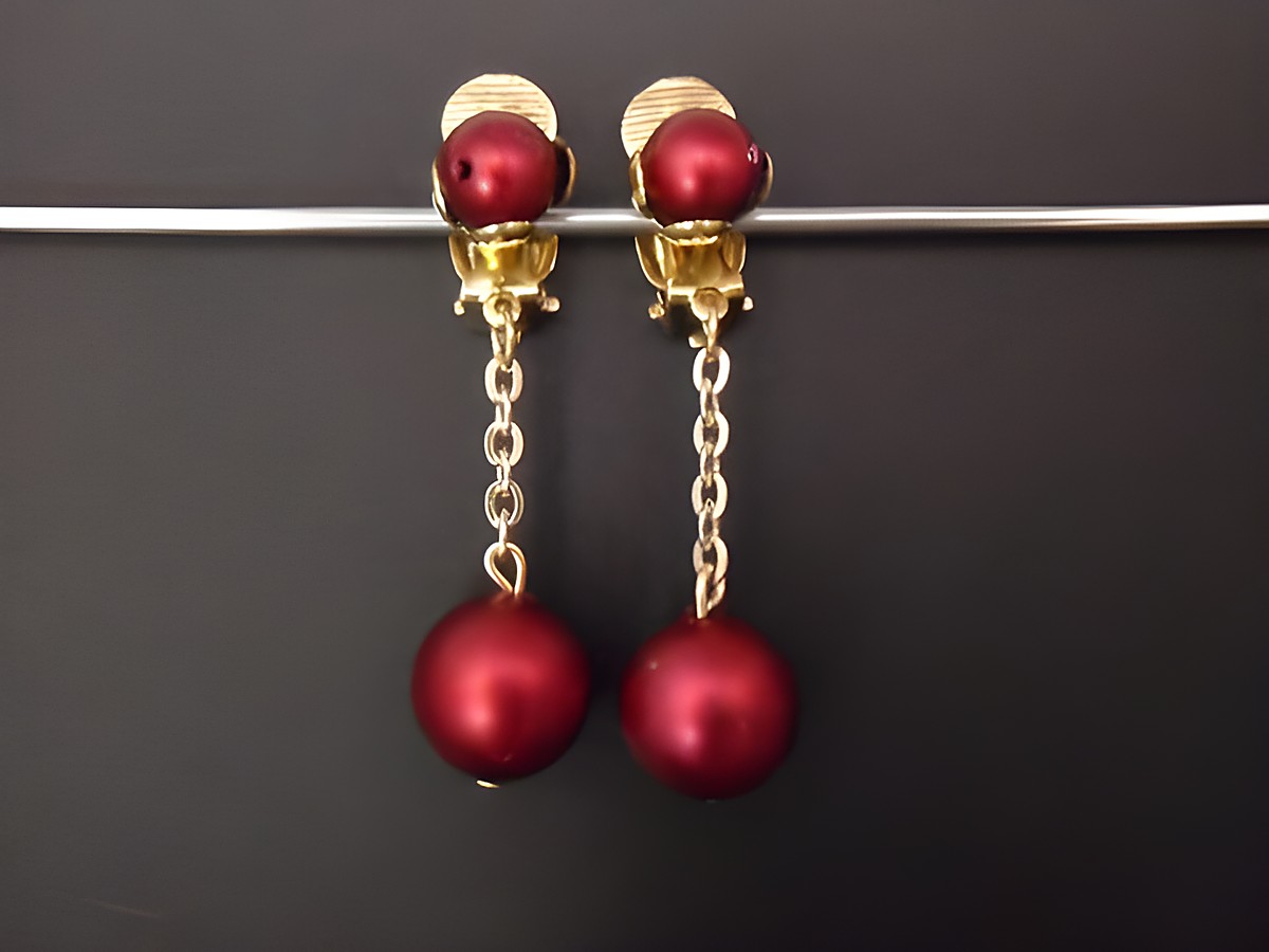 Weinrote Ohrclips aus Kunstharz mit goldfarbenen Elementen und einer eleganten Kette, zeitloses Design von Juwelier Harnisch, ideal für besondere Anlässe.